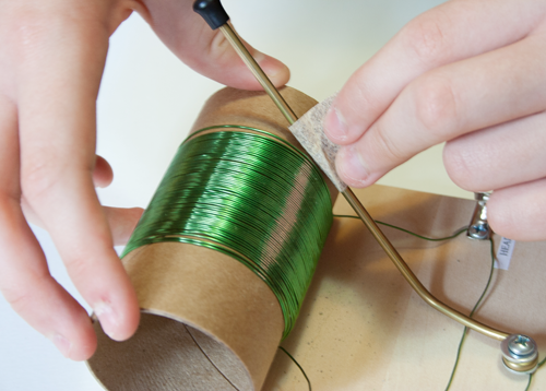 Insulation on a copper tuning rod, in a homemade crystal radio, is removed with sandpaper