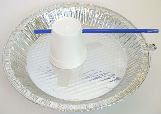 A homemade electroscope made from an aluminum pie pan, styrofoam cup, straw, aluminum foil and string