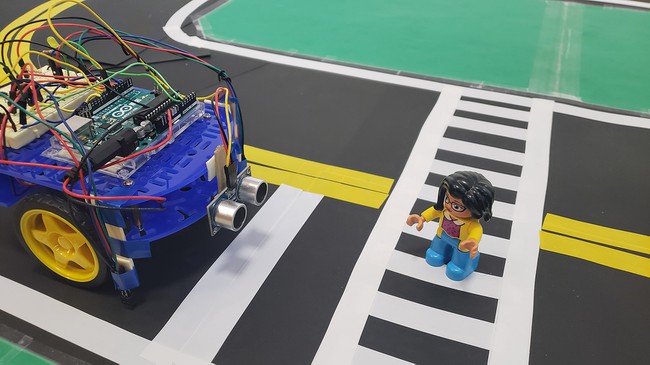 A self-driving robot car built with an Arduino stops when its sensors indicate an obstacle. 