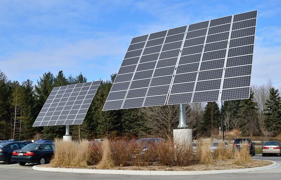  Solar panels in a parking lot mounted on large poles. 
 