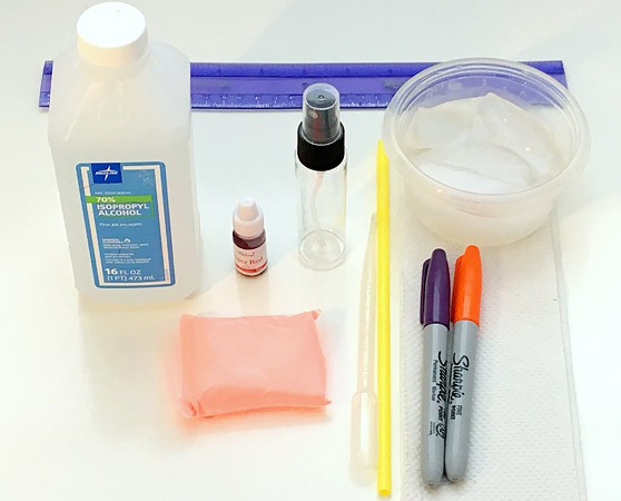 Rubbing alcohol, food coloring, a ruler, straw, markers, modeling clay, a small spray bottle and a plastic container