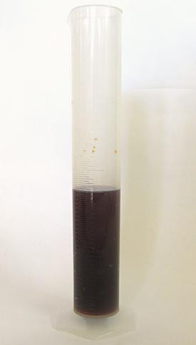 A black solution of iodine and water in a graduated cylinder