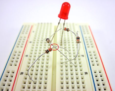 Close-up photo of a breadboard circuit shows the metal leads of two resistors touching