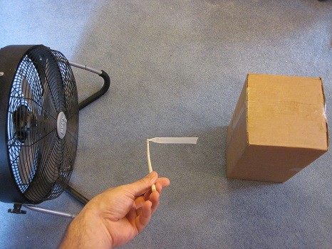 A piece of thin plastic blowing in the wind created by a fan