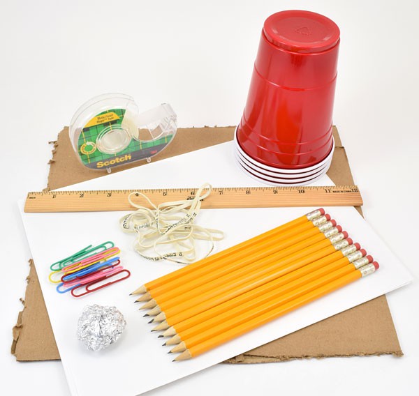 Tape, plastic cups, a ruler, rubber bands, paperclips, pencils, a sheet of cardboard and a ball of aluminum foil