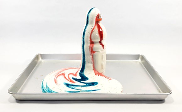 Elephant toothpaste with red and white stripes foaming up out of a plastic bottle. 