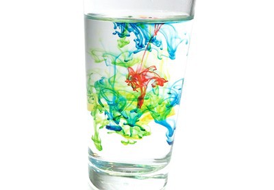 A glass of water with food coloring burst under water.