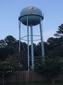  water tower, a tall structure with a thin frame and large tank of water at the top 