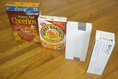 Four cardboard boxes of different sizes are lined up on a wooden floor