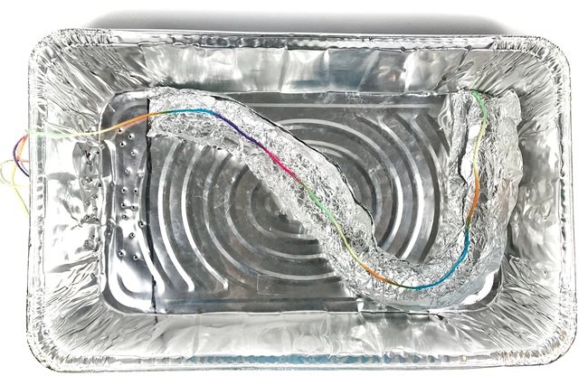  Aluminum pan with a lightly curved aluminum foil river model inside. The length of the river model is measured by laying a string inside the riverbed. 
