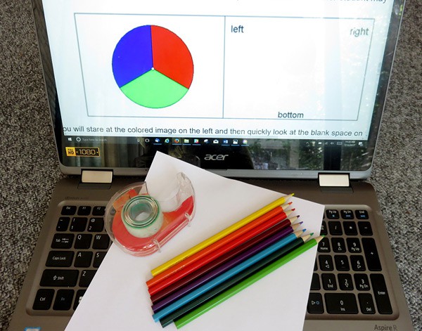 A laptop, paper, tape and eight different colored pencils