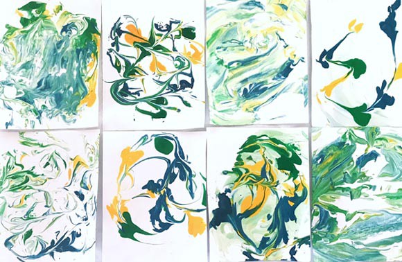Eight different patterns of green, yellow and blue streaks create a marbling effect on various pieces of paper