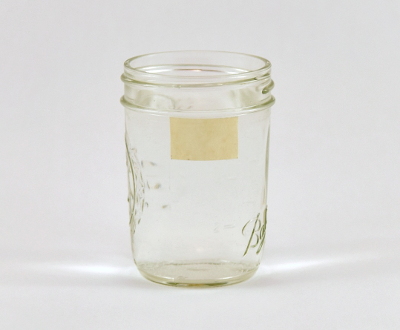 A glass jar with a small strip of masking tape on it