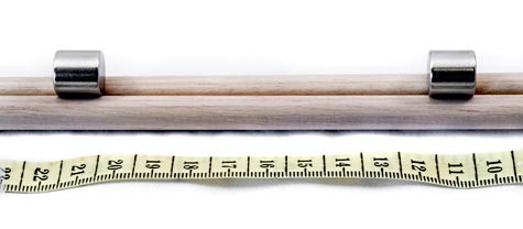 Two magnets placed ten centimeters apart on a wooden rail