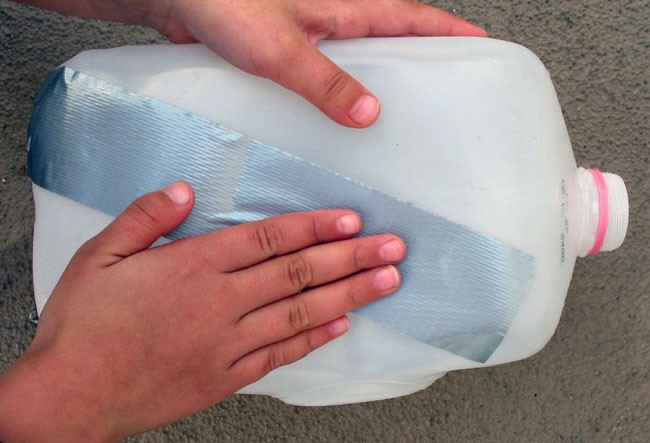 Duct tape is placed on the side of an empty milk jug