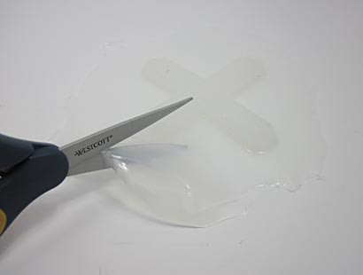 Scissors cut out a cross-shaped silicon robot from the center of a larger sheet of silicon