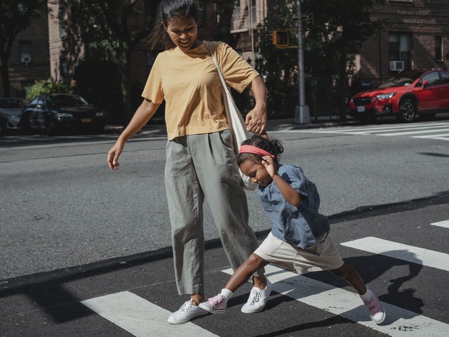 mom and daughter crossing street