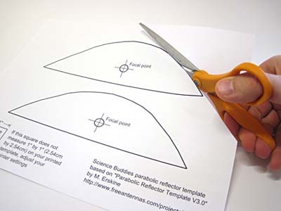 Scissors cut out a parabola from a paper template