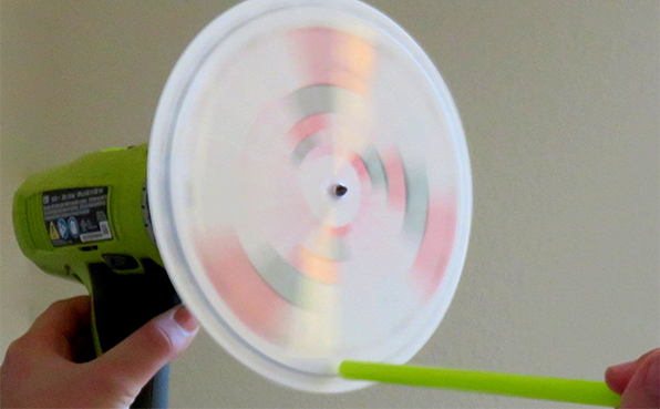 Homemade disk siren and straw being used to blow air