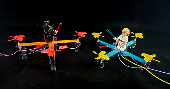 Two popsicle stick drones with Luke and Darth Vader minifigures on top