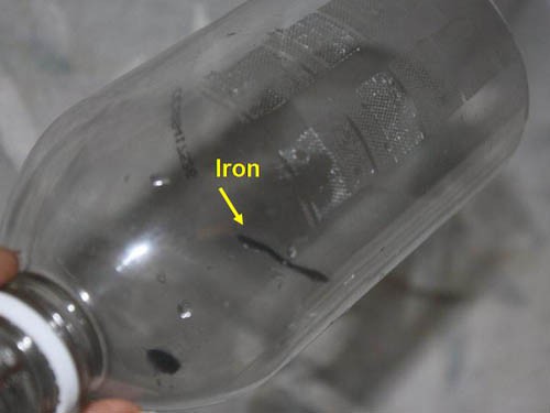 Iron particles stuck to the wall of a plastic bottle
