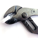 Candy held between pliers in an experiment to see if there are sparks when the candy is crushed