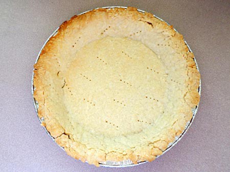 A cooked pie crust in a pie pan