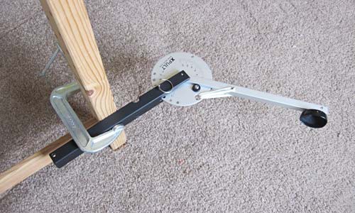 A C-clamp secures a catapult to the leg of a table