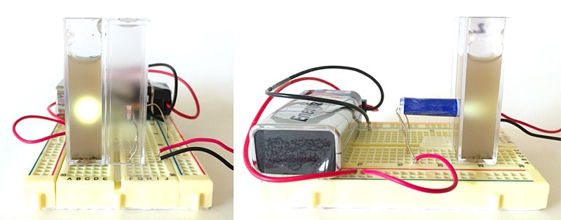 A 9 volt battery powers an LED attached to a breadboard that shines a light through a cuvette