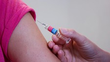 Vaccine shot being administered to an arm