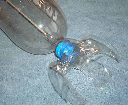 The bottom of a cut plastic bottle is attached to the bottle cap of a plastic bottle submarine