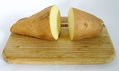 Sweet potato cut in half on a cutting board