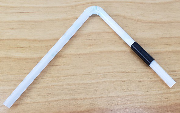 Two straws joined and connected with electrical tape. 