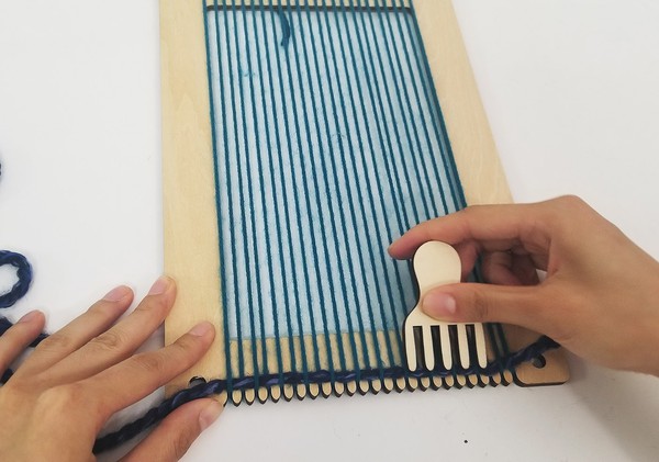Combing the row of woven yarn. 