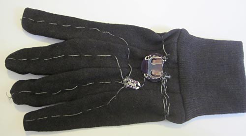 Conductive thread, a switch and a battery holder sewn onto the back of a glove