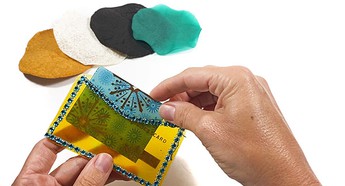 Four different biofabric patches made from different materials. A hand is placing a card in a credit card wallet made from alginate biofabrics.