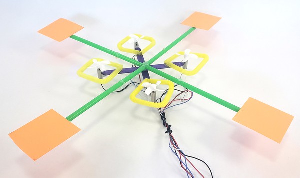  drone with four square fins added at the end of each straw on the frame. The wires are bundled together with a twist tie.