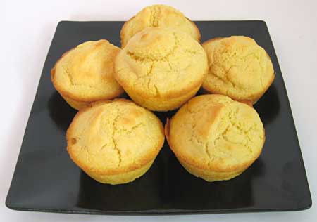 Six corn muffins piled on a plate