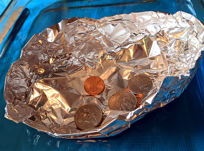Aluminum foil boat with coins added to see how much weight it can hold