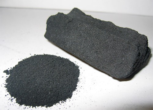 A pile of activated carbon powder next to a block of activated carbon