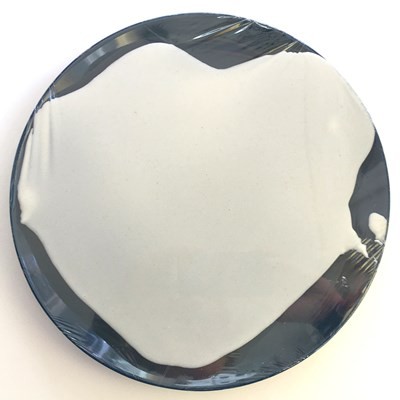 A thin layer of paste spread out evenly on top of plastic wrap like an uncooked pancake.
