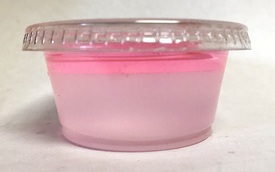 Two pink liquids separated in one small cup