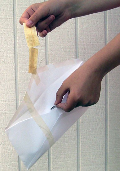 A strip of papyrus paper is glued to an envelope flap and ripped
