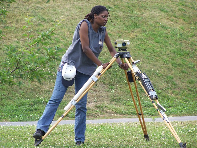 woman setting up survey equipment tide levelling survey