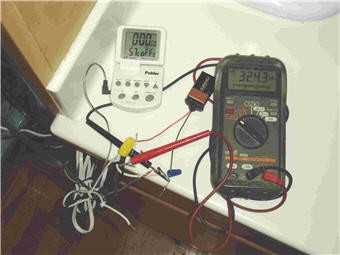 A multimeter connected to a digital temperature probe and nine volt battery