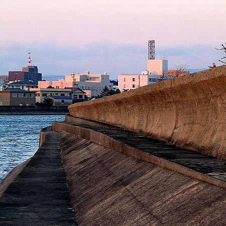 A long concrete wall has a concaved surface