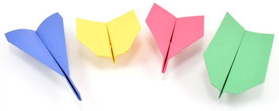 Four pieces of paper folded into different airplane designs