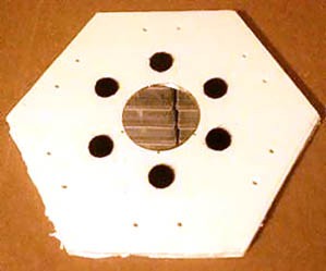 A circular mirror surrounded by six smaller circles at the center of a hexagonal formboard