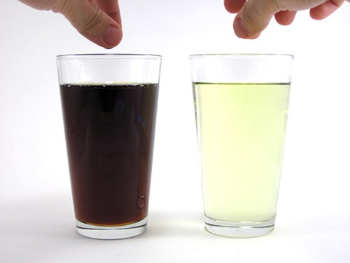 A glass cup filled with syrup next to a glass cup filled with vegetable oil
