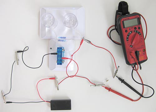 Probes of a multimeter measure voltage drop across a resistor